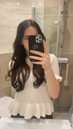 Vit stickad topp med volang från Divided - Supersöt vit stickad topp från Divided med korta ärmar och bred volangkant nedtill. Toppen har rund halsringning och ett diskret hålmönster i hela tyget. Perfekt för dig som gillar en gullig och trendig stil. I storlek L men passar mig perfekt som brukar ha xs/s vanligtvis!