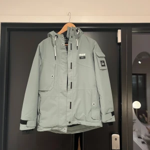 Mintgrön skidjacka Dope  - Snygg mintgrön skidjacka från Dope med huva, flera praktiska fickor och justerbara ärmslut. Den är endast använd 2 skidsemestrar så skicket är som nytt💕