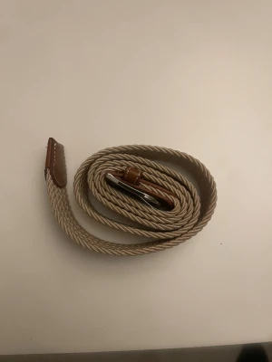 Flätade bälte beige  - Jag säljer en beige flätat bälte. Säljer för att jag inte vill ha den längre. 