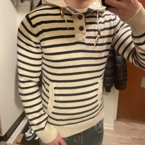 Vit blå stickad hoodie - Otroligt fet unik blå vit randig stickad hoodie i toppskick. Modellen är 180cn, 74kg (tröjan är liten på  modellen) priset går såklart att diskutera.