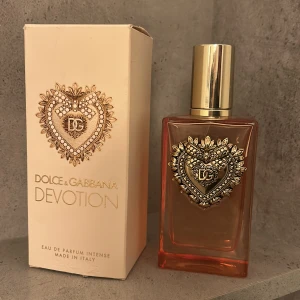 Dolce & Gabbana Devotion Parfym - Devotion Eau de Parfum Intense från Dolce & Gabbana. Lyxig design med ikonisk hjärtdetalj. Tillverkad i Italien. Perfekt för dig som vill ha en lyxig parfym som man alltid får mycket komplimanger med. Den luktar vanilj och citrus, så god och elegant!! Köpte den för ca 1400kr