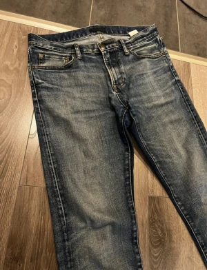 Uniqlo Faded Jeans 32/34 - Säljer dessa riktigt fina uniqlo jeans i utmärkt skick och riktigt snygg färg/stil. Passar perfekt för archive och stockholmstilen. Den är knappt använd och i storlek W32 L34. Skriv gärna vid intresse!