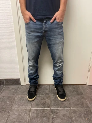 Jack & Jones Slim/Glenn - Snygga jeans med slitningar från Jack & Jones. Mycket bra skick. Modell: Slim/Glenn. Modellen är 173cm, 64kg. Pris kan diskuteras!!