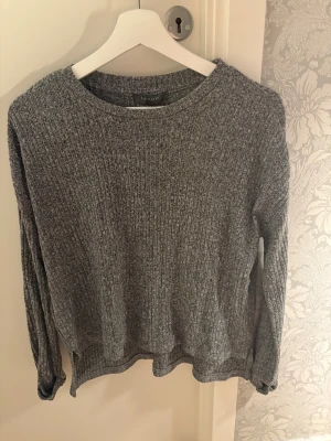 Grå ribbad stickad tröja Primark XS - Mysig grå stickad tröja från Primark i storlek XS. Tröjan har ett ribbat mönster och rund hals, med långa ärmar och en loose passform. Perfekt för dig som gillar enkel och chill stil med lite struktur i materialet.