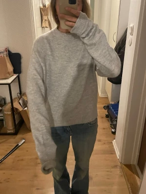 Grå stickad tröja med långa ärmar - Mysig grå stickad tröja, aldrig använd. Väldigt långa ärmar 
