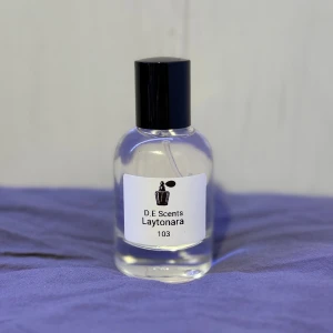 Parfym Laytonara - Denna doft är en blandning av fruktiga och aromatiska noter. Den har en öppning av citrus och örter, ett hjärta av frukt och blommor, och en bas av söta och träiga noter. Denna doft påminner om PDM Layton Storlek: 50ml