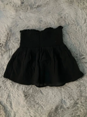 Svart topp  - En jättefin svart topp utan axelband från ginatricot, i storlek 146/152 eller Xxs ungefär. 