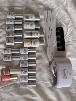 Depend Gellack kit med UV-lampa - Komplett Depend Gellack kit med UV-lampa, flera flaskor gellack i olika nyanser, top coat, cleanser och remover. Inkluderar även nagelfilar, tåseparator och två vanliga nagellack i rosa och korall. Perfekt för att fixa snygga gelnaglar hemma.