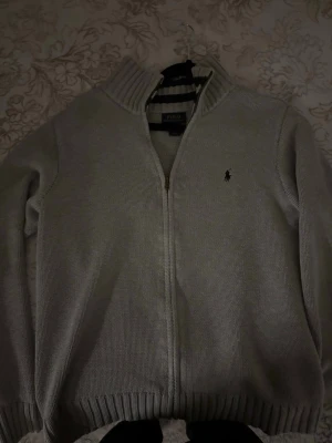 Grå kofta från Polo Ralph Lauren - Säljer en stilren grå kofta från Polo Ralph Lauren i storlek L (14-16 i barnstorlek)