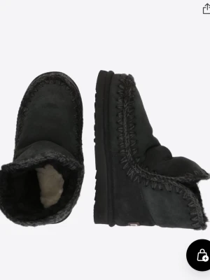 Mou vinter skor  - Mysiga svarta boots med grov stickad kant och mjukt pälsfoder på insidan. Skorna har en rund tå och platt sula, perfekta för kalla dagar. Materialet är mocka och päls, vilket gör dem extra varma och sköna. De är använda.