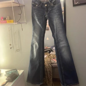 Blå lågmidjade bootcut jeans från 157 - Aldrig använda. Köpte för 400kr. Snygga blå jeans från 157 med bootcut passform och klassisk femficksdesign. Jeansen har låg midja och är tillverkade i slitstarkt denim med ljusa tvättade detaljer. Perfekta för dig som gillar retrovibbar och vill ha ett par jeans med lite extra vidd nedtill.