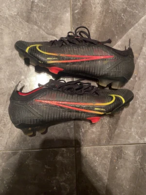 Nike Mercurial svarta fotbollsskor - Säljer ett par Nike Mercurial fotbollsskor i svart o röd  gammal modell som it säljs längre. Bra skick utan några hål o så förutom lite slitna dobbar annars bra skick 