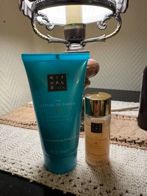 Rituals The Ritual of Karma body shimmer - Oöppnade. Rituals The Ritual of Karma shimmering body gel i en liten flaska med guldfärgat lock. Ger huden en skimrande finish och innehåller lotus och vit te. Perfekt för att ge kroppen extra glow. Säljs tillsammans med en återfuktande body lotion i turkos tub.