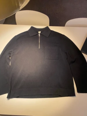 Arket stickad tröja med dragkedja - Mörkblå stickad tröja med dragkedja och krage i avslappnad passform från arket. Använd endast ett fåtal gånger och i mycket bra skick. Nypris är 990kr. Perfekt nu till kallare väder.  Storlek M, men är lite stor i storleken, fungerar som en L också.