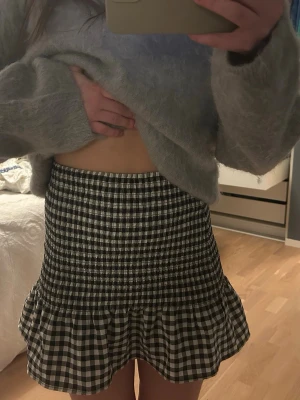 Svartvit rutig minikjol med volang - Går o vika ner snyggt