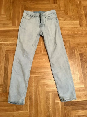 Slim fit ljusblå jeans från H&M - Slim fit jeans från H&M i en snygg ljusblå tvätt. Klassisk femficksmodell med dragkedja och knapp framtill. Jeansen har raka ben och är tillverkade i bomullsmaterial med lite stretch för skön passform. Perfekt för dig som gillar en clean och enkel stil.