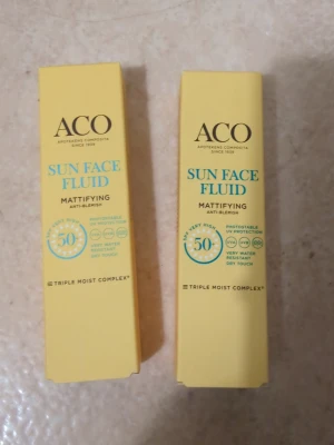 EN för 150 kr☺️ - ACO Sun Face Fluid Mattifying Anti-Blemish är en ansiktsfluid med SPF 50 som ger mycket högt solskydd. Produkten är gul med blå och svart text, har en mattande effekt och är vattenresistent. Innehåller Triple Moist Complex för extra fukt och passar dig som vill ha ett lätt solskydd för ansiktet.