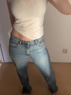 Straight leg jeans - Säljer ett par klassiska denimjeans i ljusblå tvätt. De har rak passform, låg midja och fem fickor. Jeansen är i ett mjukt denimtyg och har den ikoniska knappgylfen. Perfekta för en avslappnad och trendig look.