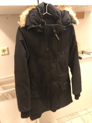 Canada goose Trillium Parka xxs  - Säljer en svart parkas från Canada Goose i storlek XXS. Jackan har stor huva med päls , flera fickor framtill och stängs med både dragkedja och knappar. Perfekt för kalla dagar med sin rejäla och varma design.