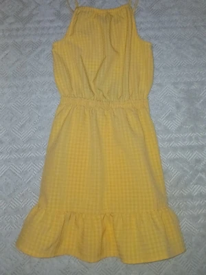 klänning storlek 134 - Orange klänning i superfint skick, håller i ryggen med volang där nere. Inget fel på den alls men har växt ut den! +frakt