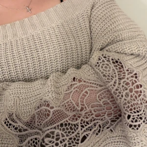 Beige offshoulder stickad tröja med spets - Superfin beige stickad tröja som kan bäras offshoulder eller oneshoulder och har bred ribbad kant. Ärmarna har snygga spetsdetaljer som ger en unik look. Strl L men mer som en oversize tröja för mig med strl XS/  är loose fit och passar perfekt för dig som gillar avslappnad stil med lite extra detaljer.