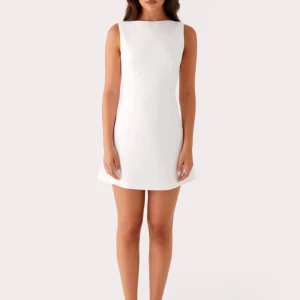 Vit ärmlös kortklänning med öppen rygg - Ny oanvänd jättefin klänning som passar super bra till studenten. Säljer den då jag beställde fel, och inte hann skicka tillbaka den..den är i storlek 38 men skulle passa en 36 då den figursydd!