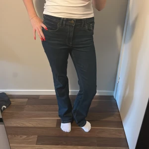 Mörkblå bootcut jeans - Snygga mörkblå jeans med klassisk bootcut passform och kontrastsömmar. Modellen har fem fickor, normal midja och är tillverkad i slitstarkt denimtyg. Perfekt för dig som gillar en tidlös och clean look.