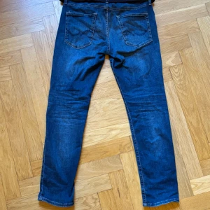 Mörkblå slim-fit jeans - Riktigt snygga mörkblå slim-fit jeans. W33/L30. Några skavanker (se bild) men märks inte mycket vid användning.