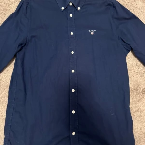 Gant Skjorta - Säljer denna skjortan från Gant för juniorer. Skjortan har storleken 158-164. Den har endast använts ett fåtal gånger och har inga defekter. Den har en normal passform och sitter skönt på kroppen. Om du har några frågor eller prisförslag är det bara att skriva. 