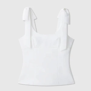 Topp med rosetter - Supersöt vit linnetopp med breda axelband som knyts i stora rosetter. Toppen är aldrig använd och är i ett super bra skick! Storlek XS🤍