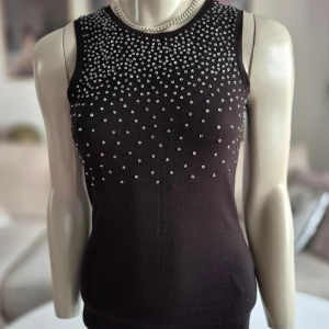 MEXX * svart topp med paljetter *stl S-M - Perfekt för nyårsfesten! * Svart ärmlös topp med dekorativa silverfärgade detaljer framtill i form av paljetter.  * Perfekta festtoppen. * Mycket bra kvalité.  * Bra skick.  * Oklar stl. S-M.  * Se mått bland foton.   Djur och rökfritt hem. Se bilder och förstora då de ingår i beskrivningen.  Se gärna mina övriga annonser. 