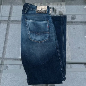 Replay x FC Barcelona Blue Jeans Anbass – strl 33 - Snygga blue jeans från Replay x FC Barcelona – modell Anbass i storlek 33. Klassiska denimjeans i blå tvätt med stilfulla slitningar och exklusiva Barça-detaljer. Skön stretch och riktigt bra passform. Perfekt blandning av stil, komfort och kvalitet. Väldigt bra skick och redo för nya äventyr!  📏 Storlek: 33 👖 Modell: Replay Anbass (FC Barcelona Edition) 🎽 Färg: Blue denim ✨ Skick: Mycket bra 