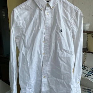 Ralph Luren skjorta - Oxfordskjorta i barnstorlek, kille, skulle säga att den passar upp till 170/175. För liten för mig, därav säljer jag. Skjorta som passar till de flesta sammanhang, allt från finare tillställningar till mer lugna tillfällen. Slim fit och buttondown krage. Bra skick, inga anmärkningar, nypris ca 1000. Hör av dig vid frågor!