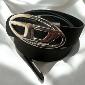 Vintage diesel Belt  - Snyggt svart bälte med bred rem i skinn och en stor, ovalformad spänne i blankt silver. Spännet har en modern, geometrisk design som sticker ut och ger en cool touch till din outfit. Perfekt för att lyfta jeans eller klänning.