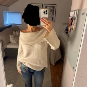 Beige offshoulder stickad tröja - Superfin beige/crèmefärgad stickad tröja med bred offshoulder-krage som ger en chill och snygg vibe. Mjuk ribbad struktur och långärmad modell. Storlek S.