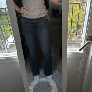 Grå jeans från Zara - Snygga grå jeans från Zara med klassisk femficksdesign. Jeansen har normal passform och är tillverkade i ett mjukt jeanstyg som sitter skönt. Perfekt för dig som gillar en stilren look med lite retrovibe.