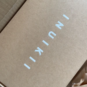 Inuikii tofflor i storlek 39 - Säljer ett par snygga tofflor från Inuikii i svart med flätad ovandel och vit platt sula. Sandalerna har en modern design och är perfekta för dig som gillar trendiga och bekväma skor. Helt oanvända och nya!