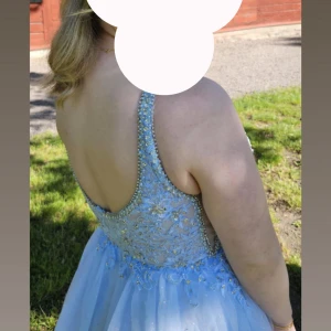 Ljusblå balklänning med glitter och spets - Säljer nu min älskade balklänning från märket maskara, använd 2 gånger. En ljusblå klänning med 4 lager på kjolen, 2 lager tyg+2 lager tyg. Smala axelband och pärlor+spets upptill. Är en 38 men passar även 36 (medium men passar en small) 