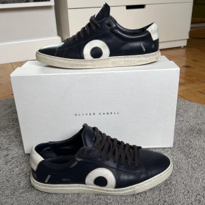 Mörkblåa Oliver Cabell Skor - Snygga mörkblåa sneakers från Oliver Cabell i skinn med vita detaljer och rund tå. Skorna har en vit sula och mörka snören. Perfekta för dig som gillar stilrena men ändå unika sneakers. Skriv om du har frågor eller behöver fler bilder!