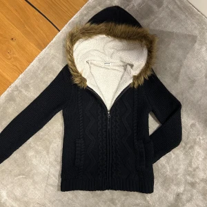 Stickad hoodie med päls - Tjoo, säljer en fet vintrig fodrad stickad hoodie med pälsluva 💯💯‼️ Väldigt varm och skön✅✅ nopprad✅✅ Skick 9/10✅✅ DMa📩 vid minsta fundering eller prisförslag🤗🤗 Kolla min profil för mer✌️ stickad hoodie med pälsluva fodrad varm päls fur abercrombie fitch hollister cardigan jacka 