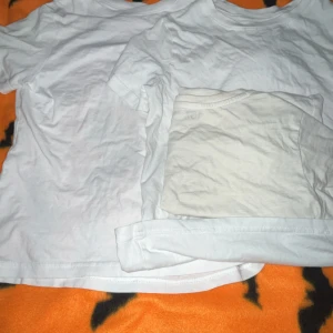 Vita basic t-shirts i bomull - Två klassiska vita t-shirts i enkel och stilren design. Båda har rund halsringning och korta ärmar, perfekta att matcha med jeans eller shorts. Tillverkade i mjuk bomull för en skön känsla hela dagen.