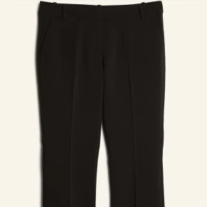 Lågmidjade Svarta vera kostymbyxor bikbok petite med  bootcut - Lågmidjade snygga svarta kostymbyxor med bootcut passform. Petite modell passar någon runt 160. Gamla modellen med slits längst ner på sidorma. Knappt använda men har annat par jag anbänfrr mer.  Perfekta för en stilren look och passar till många olika outfits.