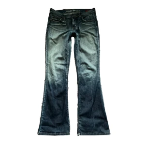 bootcut jeans - Snygga blå bootcut jeans från Guess Premium köpta i new york. I superbra skick bortsätt från slitage längst ner på jeansen! Ganska lågmidjade! Midjemått: 39cm innerbenslängd: 81cm