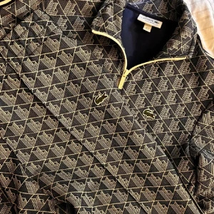 Mönstrad tracksuit från Lacoste - Säljer ett snyggt set ifrån Lacoste med byxor och kofta. Byxorna är i storlek L men skulle även passa en M och tröjan är i storlek S. Nypris är ca 4000 kronor. Priset är diskuterbart! Skriv gärna vid intresse.