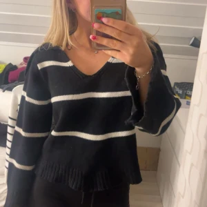 Svartvit randig stickad tröja Lindex - Svart stickad tröja från Lindex med vita ränder. Tröjan har v-ringning, långa ärmar och bred ribbad kant vid ärmslut och nederkant. Perfekt för dig som gillar en chill och snygg look.❤️