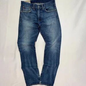 Jeans Ralph Lauren - Snygga blå jeans från Polo Ralph Lauren med klassisk femficksdesign och läderpatch bak i midjan. Jeansen har en rak passform och är tillverkade i 98% bomull och 2% elastan för extra komfort. Faded tvätt ger en cool, avslappnad look.                                                                                      Tveka inte att höra av dig vid minsta fundering!