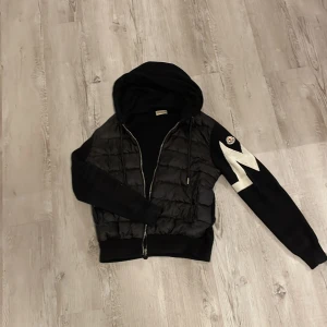 Svart cardigan Moncler - Svart moncler cardigan nytt skick  köptes för 2,200kr. Scannen fungerar och tar dig till riktiga moncler hemsidan.
