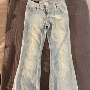 Ljusblå bootcut jeans från Lee - Säljer ett par lågmidjade ljusblå bootcut jeans från Lee. Det är jätte skön passform och material, nästan inga tecken på användning. Det står att storleken är 28x31, skulle säga att de sitter mer som 36. Färgen är så snygg och passar till nästan allt. De är väldigt prisvärda då de köptes för mycket mer! Skriv för mått och mer bilder.
