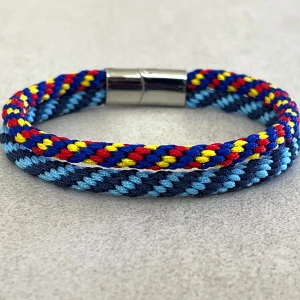 Djurgården armband 20cm - Priset på armbandet är fast, knappen ”prisförslag” går inte att dölja.  Nytt handflätat armband i Djurgårdens färger med spänne i rostfritt stål, ca 20cm och 1cm brett. Det har inflätade rostfria ståltrådar som gör att det inte tänjer sig.  