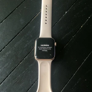 Apple Watch Series 4 - Apple Watch Series 4 med fyrkantig touchskärm och aluminiumboett i silver. Klockan har ett ljusrosa silikonarmband som är justerbart och passar de flesta handleder. Perfekt för dig som gillar smarta funktioner och stilren design.